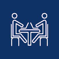 Two people sitting at a table with one of them holding the other 's hand.